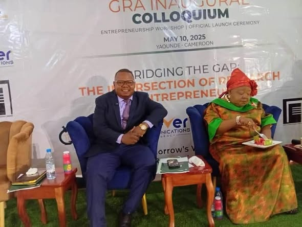 GRA Executive Director and a guest seated on stage in front of the GRA Inaugural Colloquium backdrop