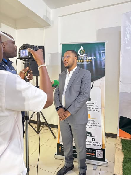 GRA spokesperson being filmed for a television interview in front of the Global Research Association banner